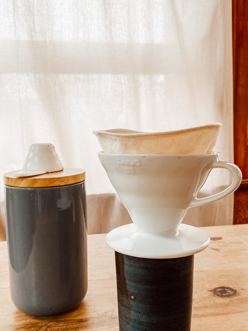 Ein Keramikaufsatz steht auf einer Tasse. Darin stecke der selbstgenähte Kaffeefilter.