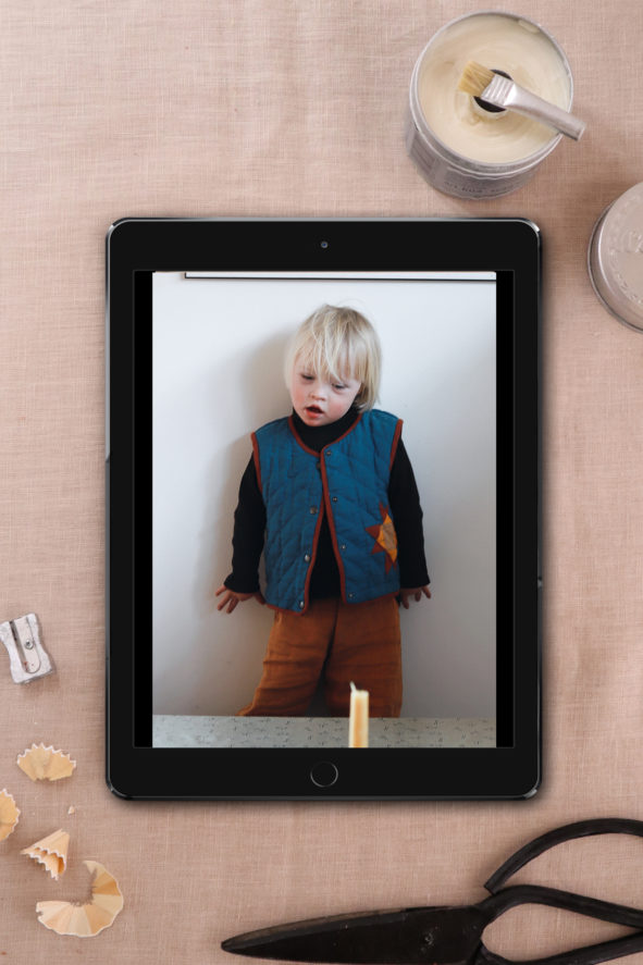 Ein Tablett liegt auf dem Tisch. Darauf ist ein Foto eines Jungen mit Downsyndrim abgebildet, der eine Weste nach dem Schnittmuster Kids Weste Malus trägt.